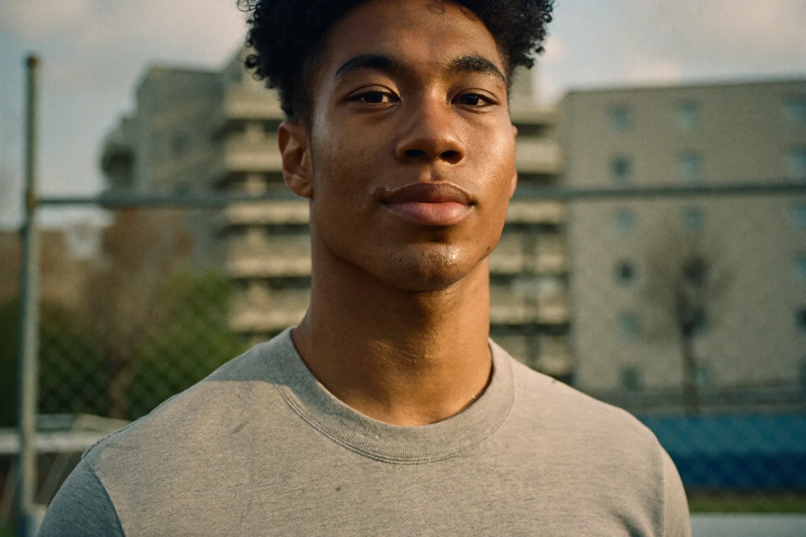Portrait d'un jeune capitaine devant un terrain de quartier